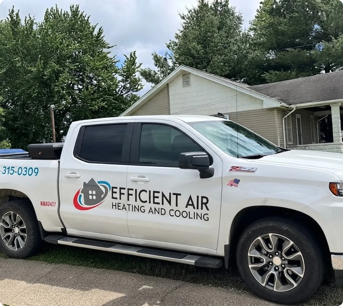 White pickup truck with “Efficient Air Heating and Cooling” logo parked on a residential street near a single-story house and trees.